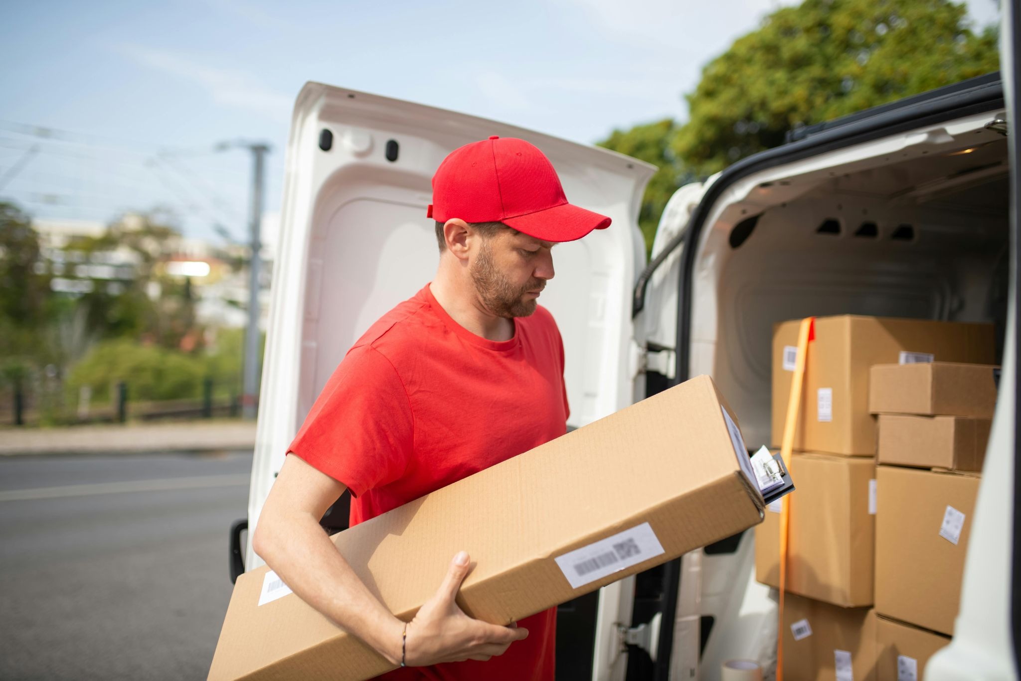 Delivery driver unloading printed marketing material boxes from van — nationwide print distribution across South Africa by Print It ZA