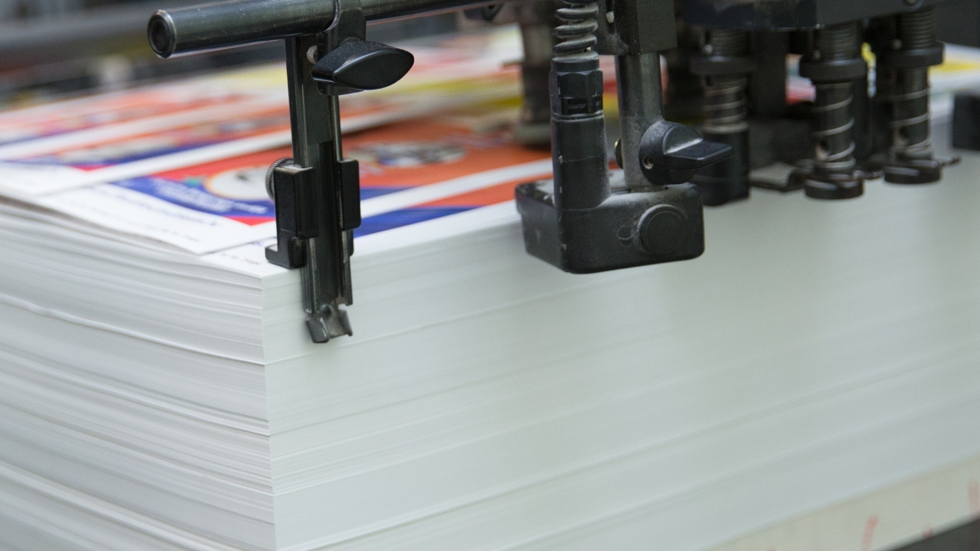 Stack of freshly printed pages on an offset printing press, as used to print training manuals.